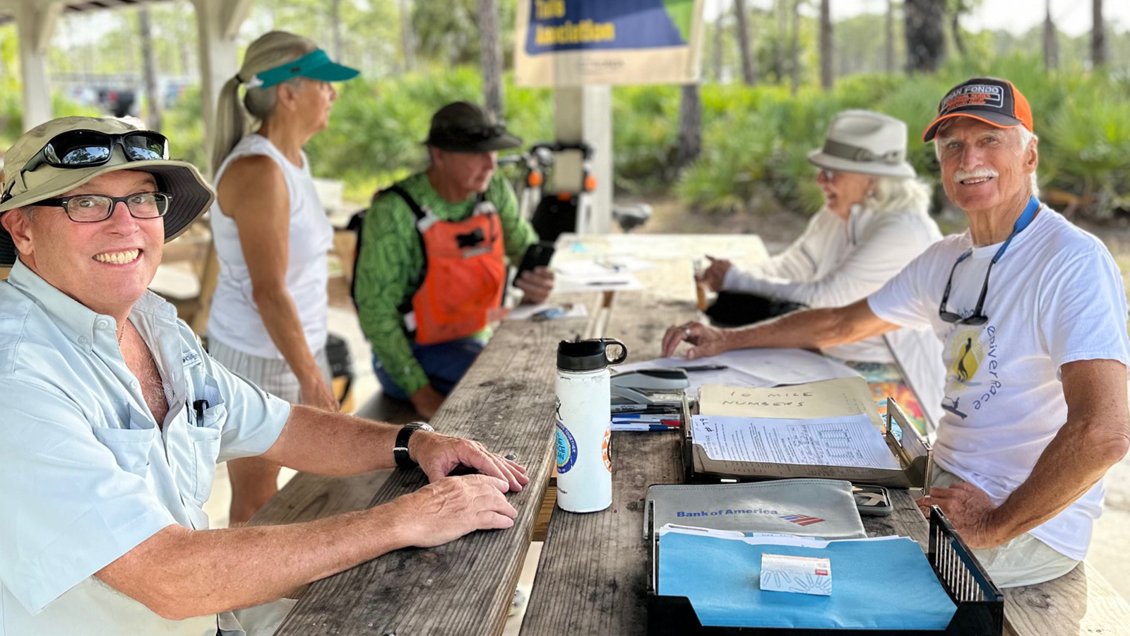 Volunteers and race officials with clipboards and paper rosters at the Great Loxahatchee River Race