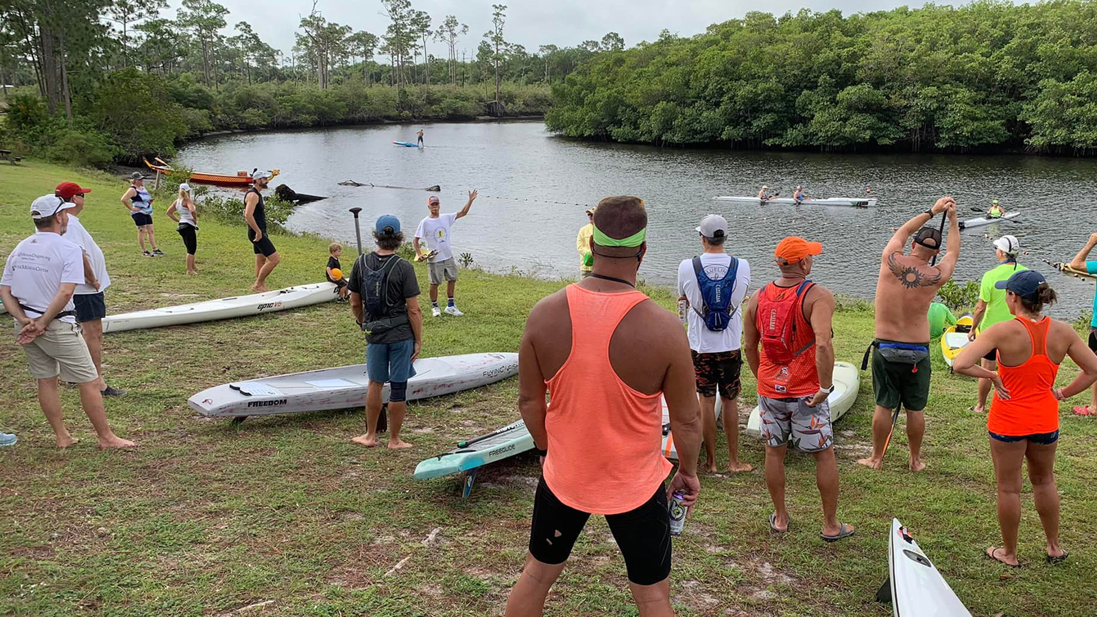 Paddlers and vessel classes gathered on the riverbank